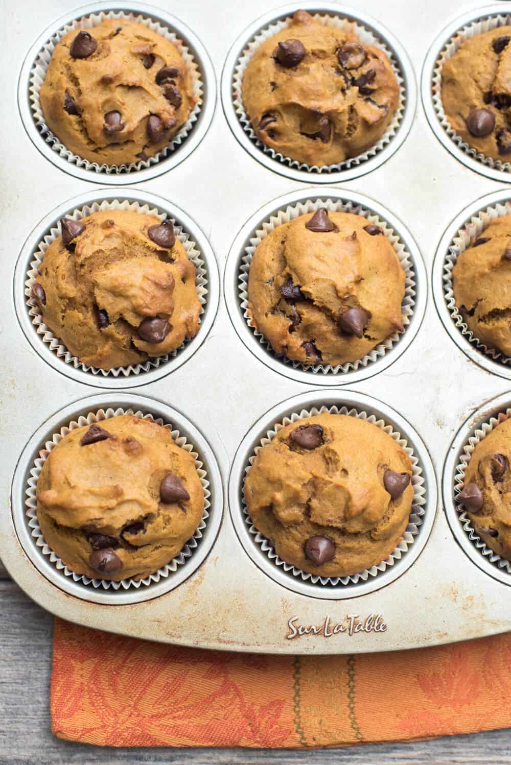 A close up of Pumpkin Chocolate Chip Muffins in a muffin tin.