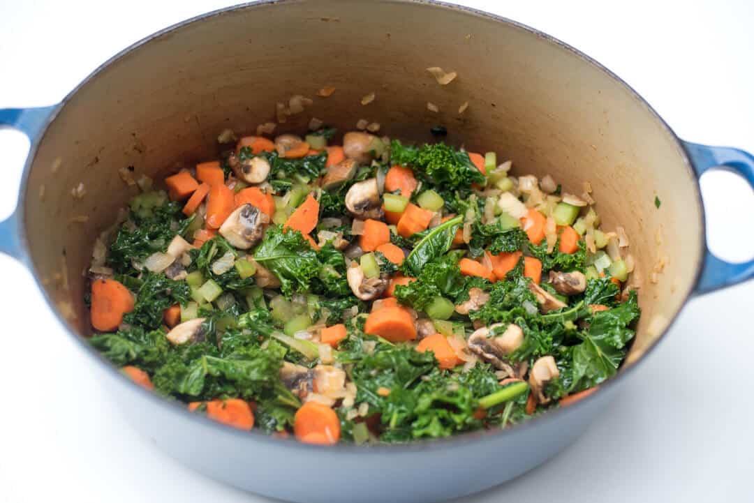 Vegetables and kale in a Dutch oven.