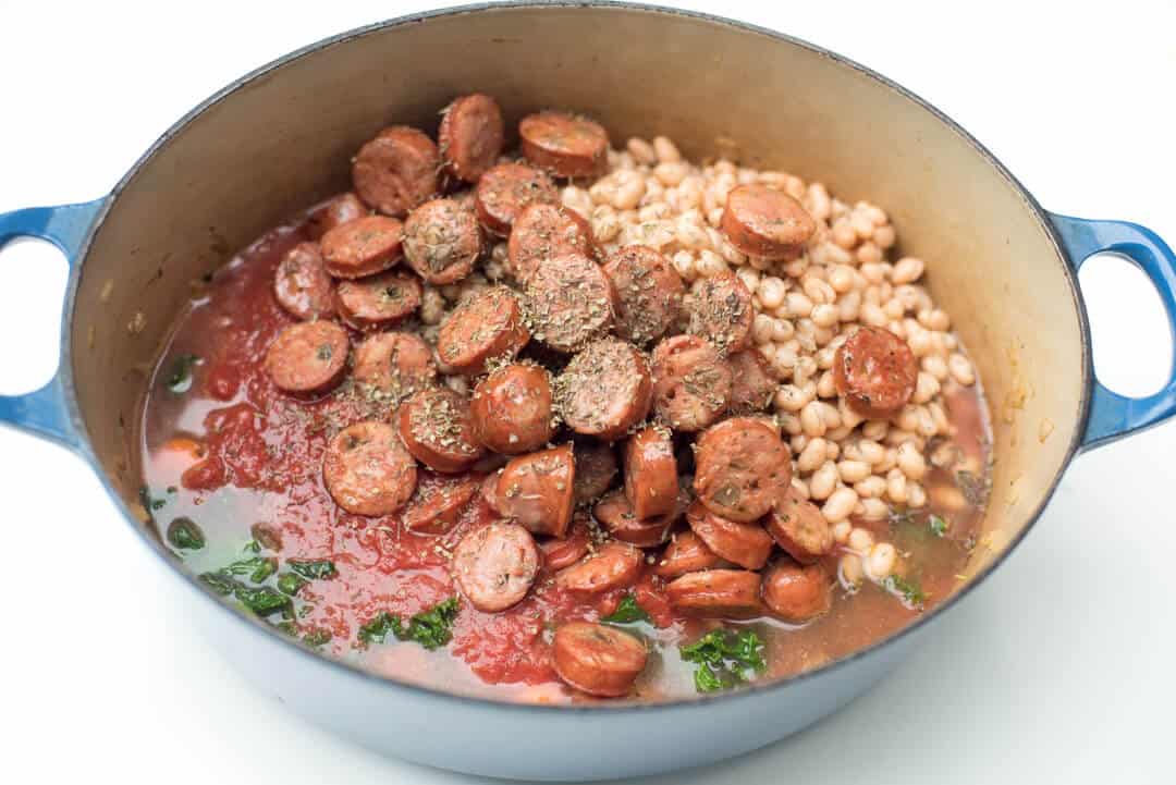 Sausage and White Bean in a Dutch oven with other ingredients.