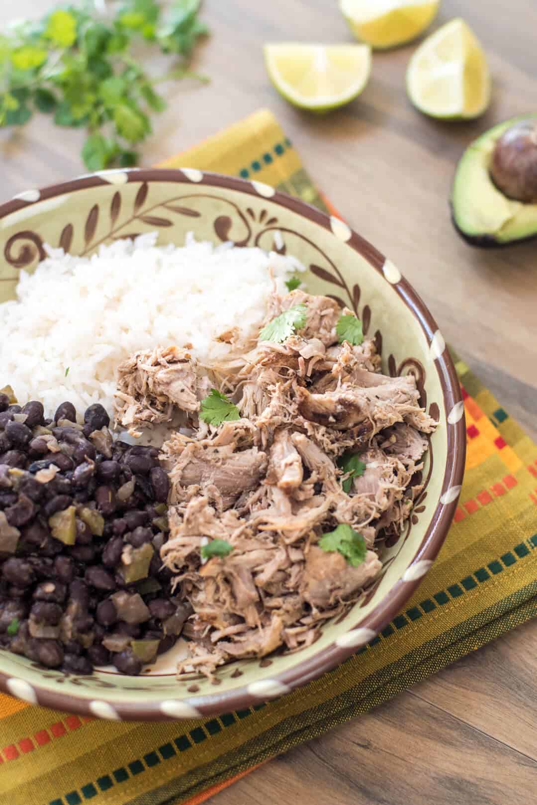 Slow Cooker Cuban Pork with Black Beans which white rice on a patterned cloth.