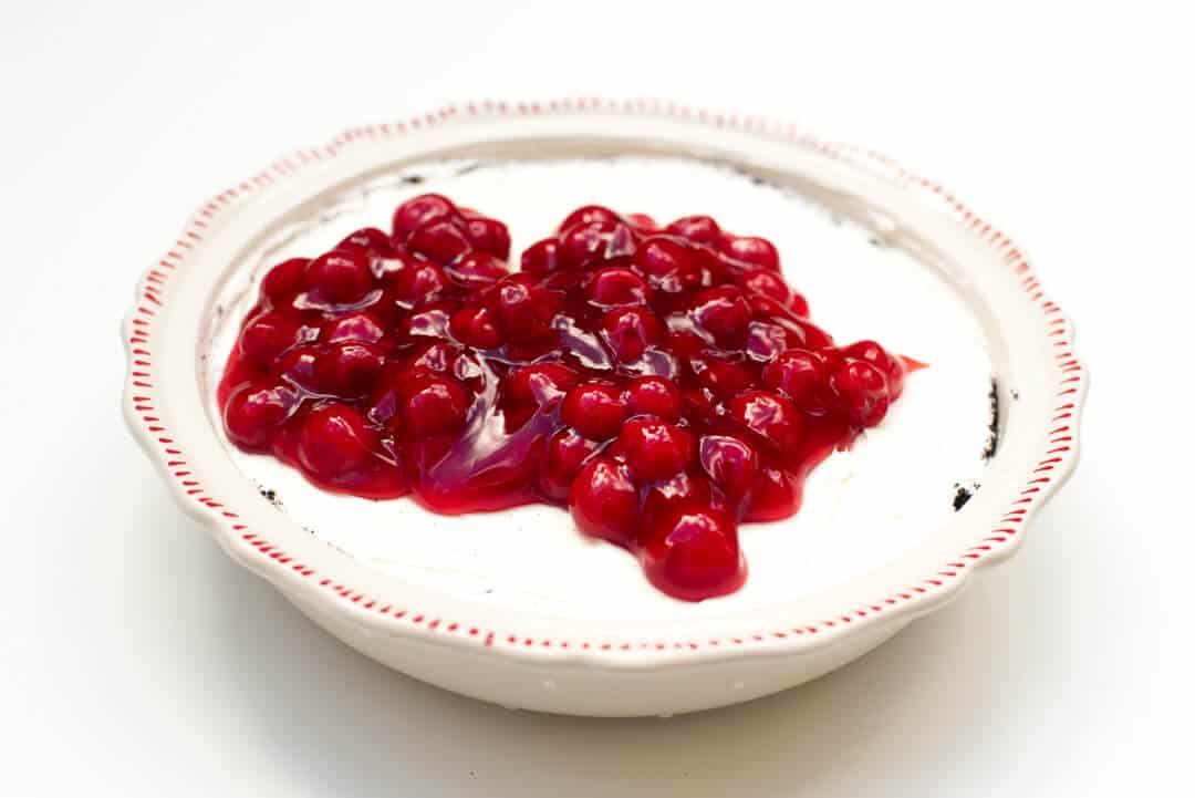 The cherry pie filling is spread over the filling.
