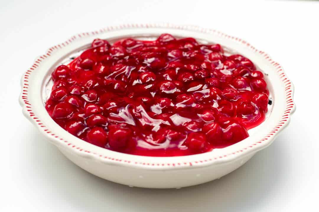 The cherry pie filling is spread out in an even layer.