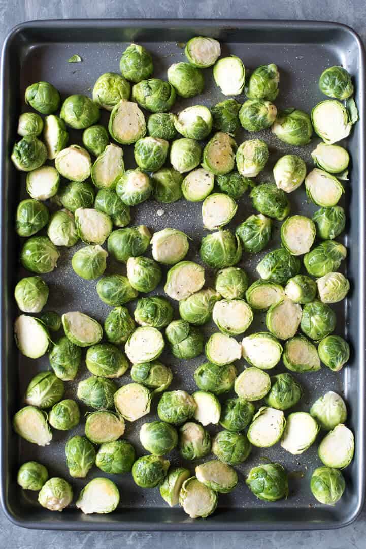 Brussels sprouts cut in half on a baking sheet.