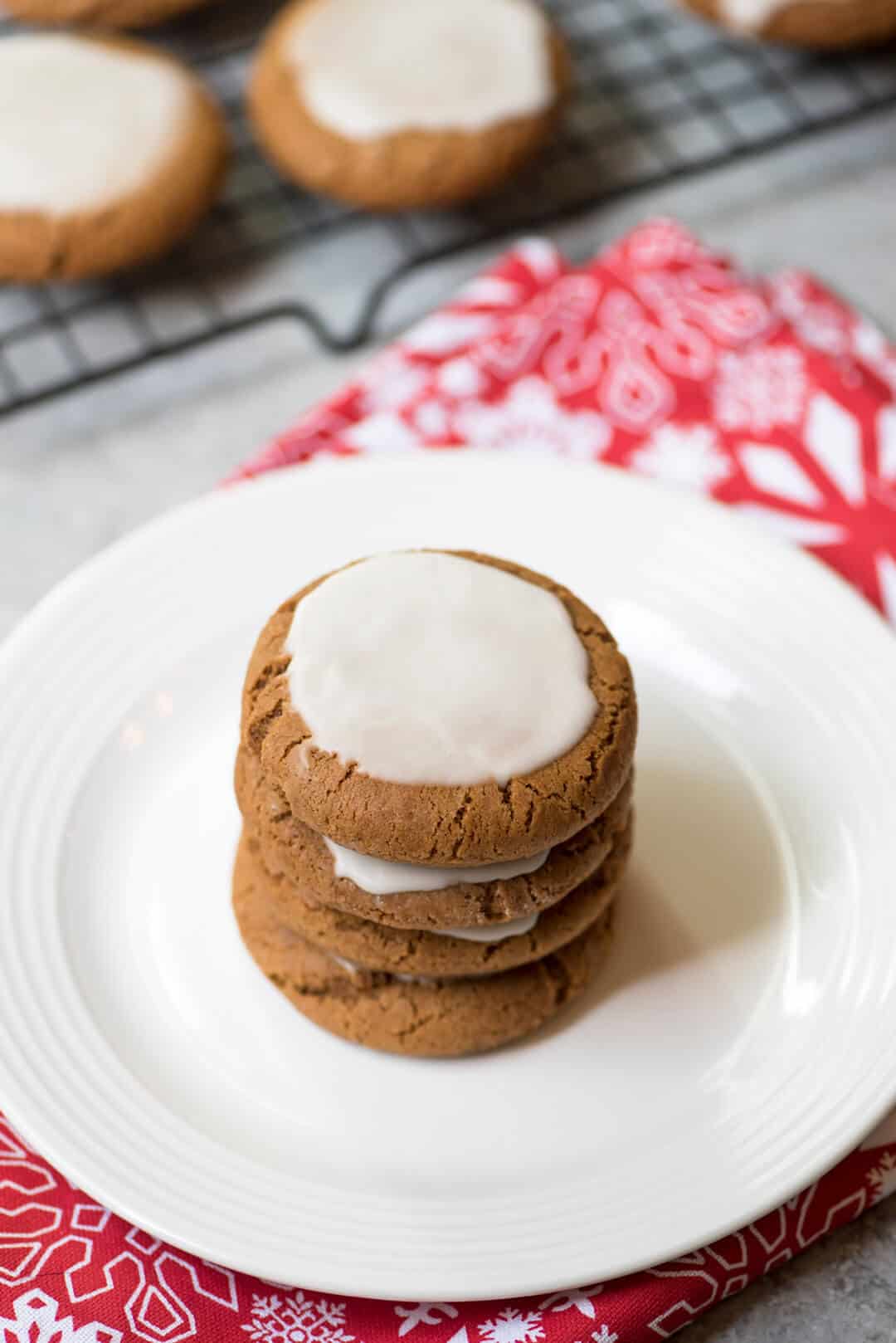 A stack of Chewy Iced Molasses Cookies on a white plate.
