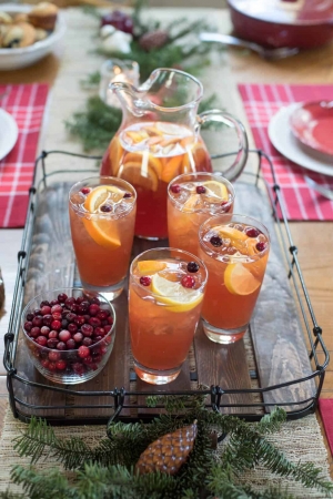 A table topped with festive table settings and a tray of iced tea.