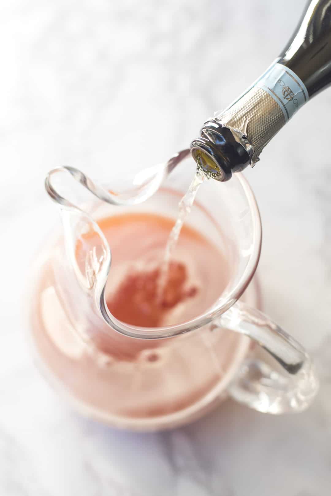 Prosecco pouring into a pitcher.