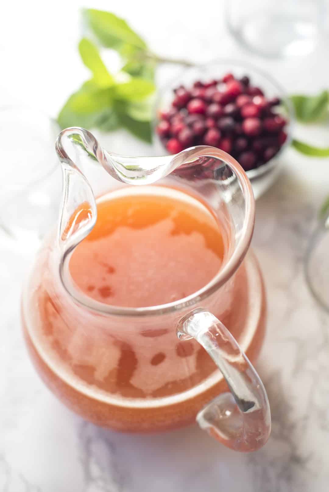 Cranberry Peach Prosecco Punch in a glass pitcher.