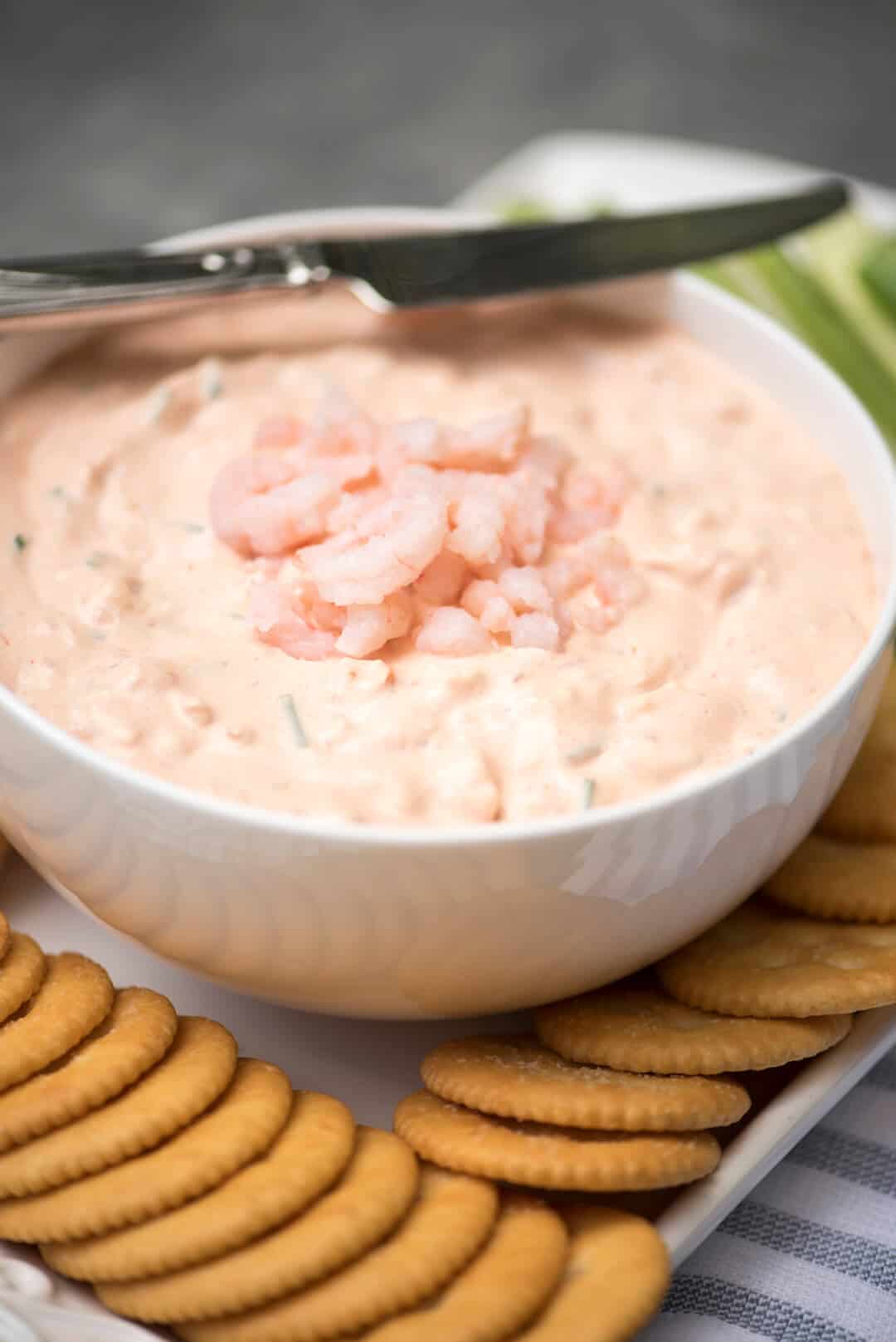 A close up of Shrimp Dip topped with small shrimp in a white bowl.