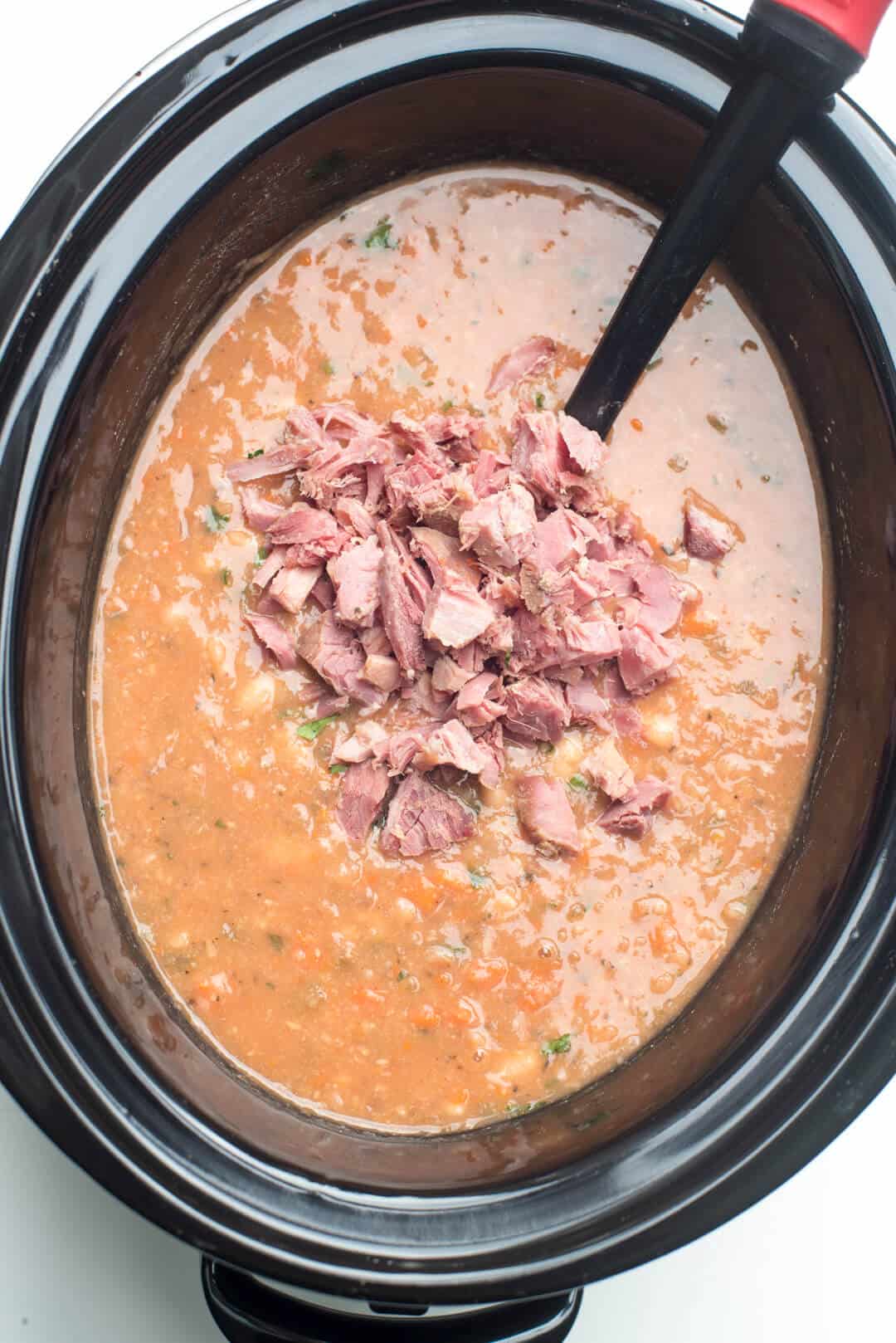 Chopped ham is added to the finished soup in the slow cooker.