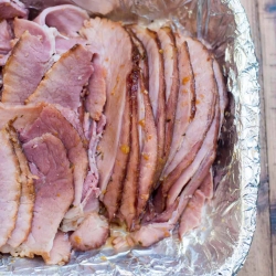 Sliced ham in a foil lined dish.