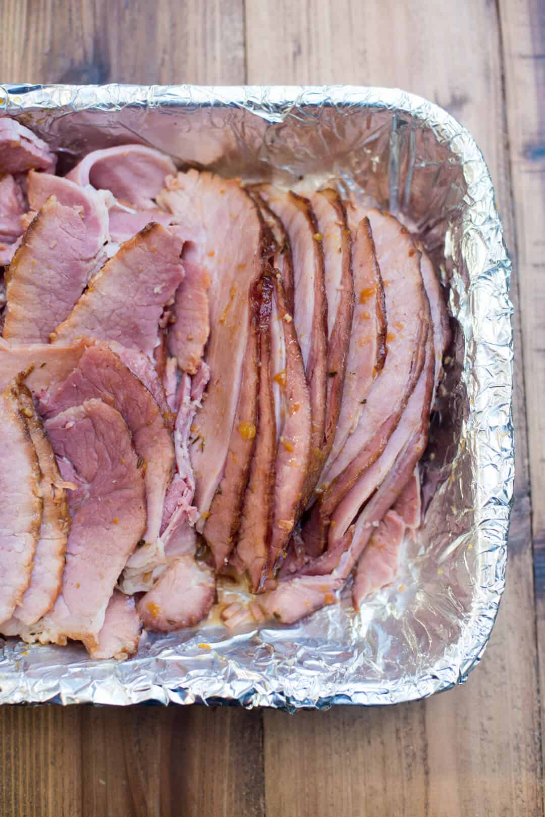 Sliced ham in a foil-lined pan.