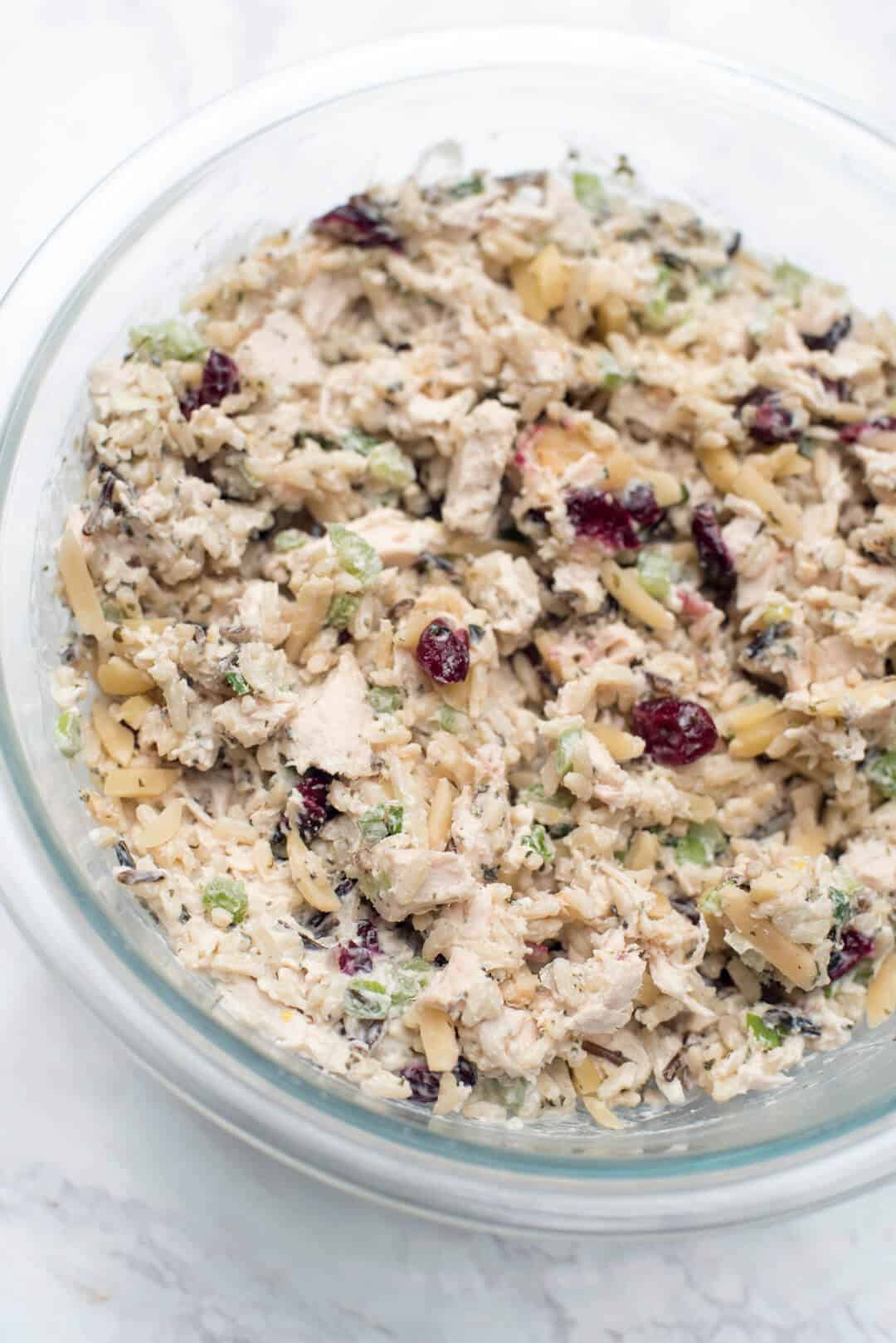 Long Grain and Wild Rice Chicken Salad with dried cranberries and almonds in a glass bowl.