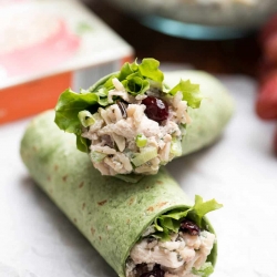 A closeup of a chicken salad wrap sliced in half and stacked.