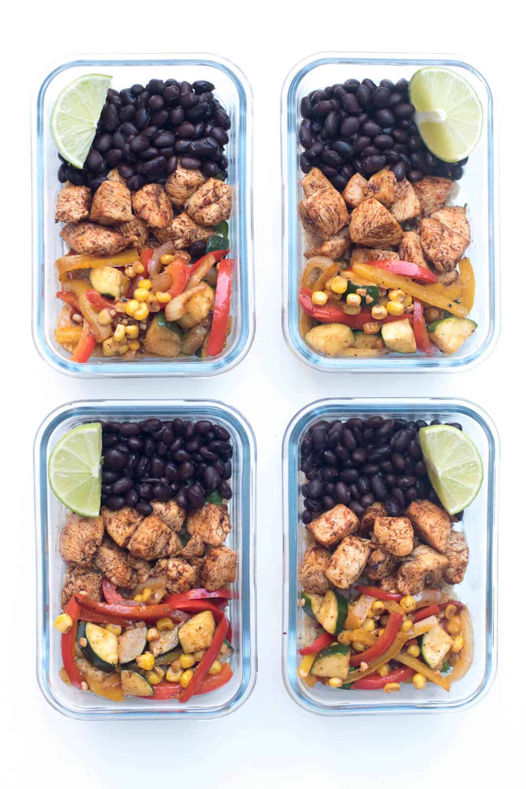 An over the top image of four meal prep containers filled with Tex Mex Chicken.