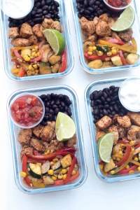 Glass meal prep containers filled with chicken, veggies, and black beans.