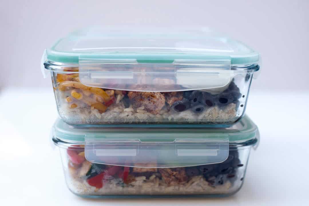 A side view of two meal prep container with the lids on and stacked.