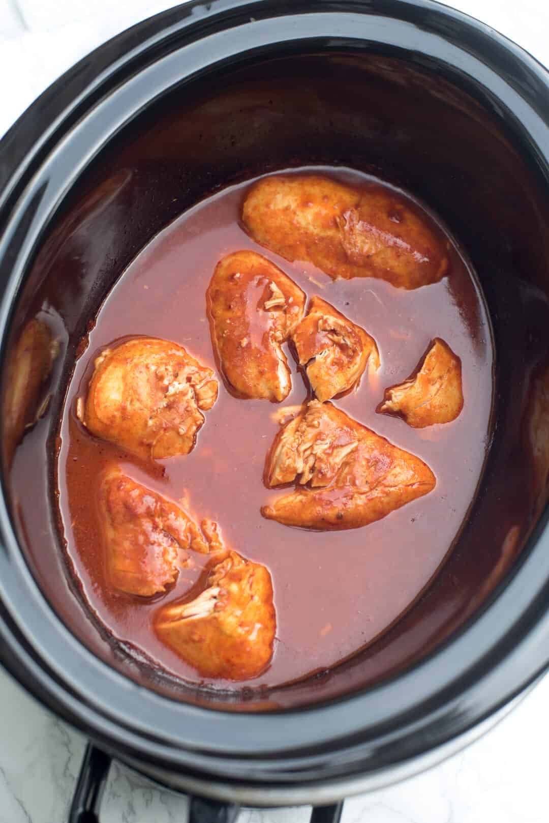 Cooked chicken in sauce in a slow cooker.