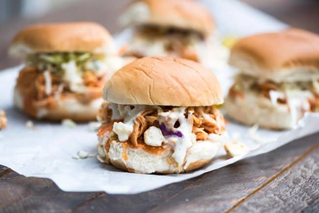 Slow Cooker BBQ Buffalo Chicken Sliders on parchment paper.