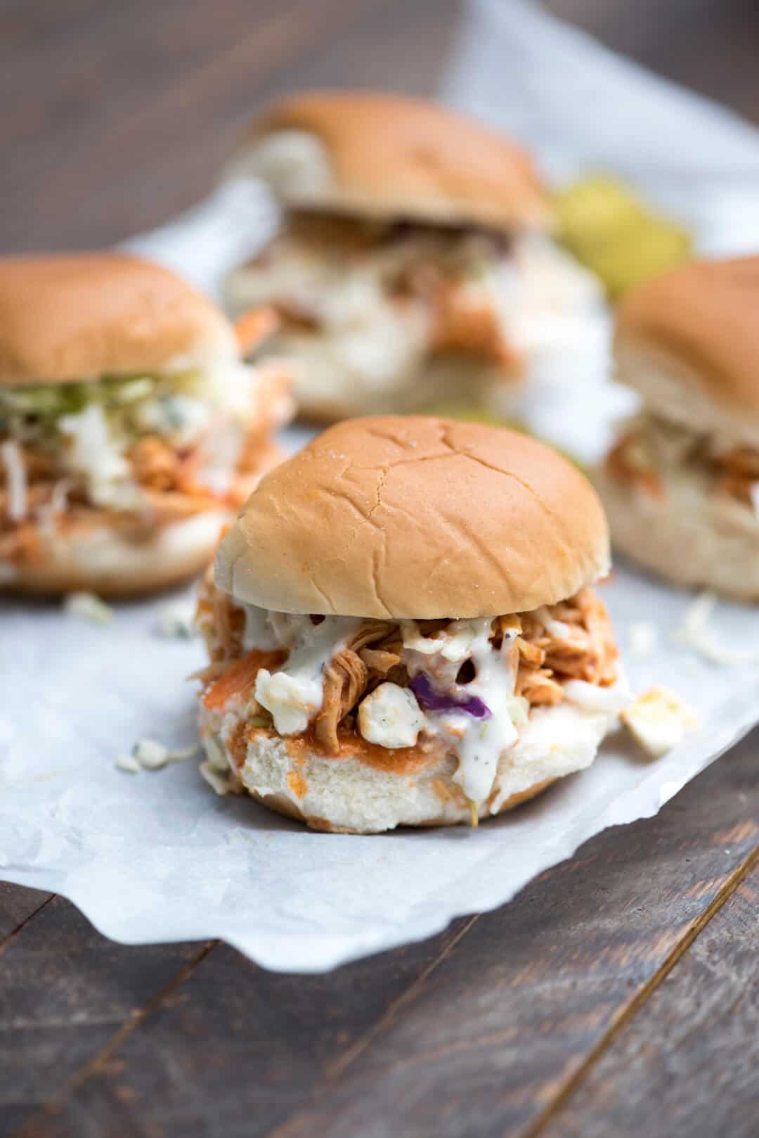 Chicken sliders with blue cheeses and Ranch on parchment paper.