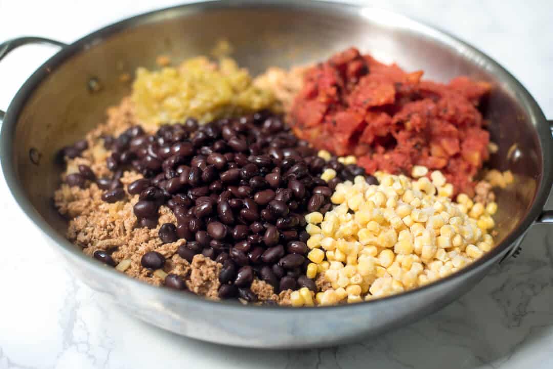 Ground turkey, black beans, corn and other ingredients in a skillet.