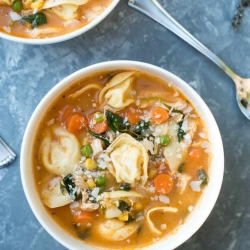 Bowls filled with chicken vegetable tortellini soup.