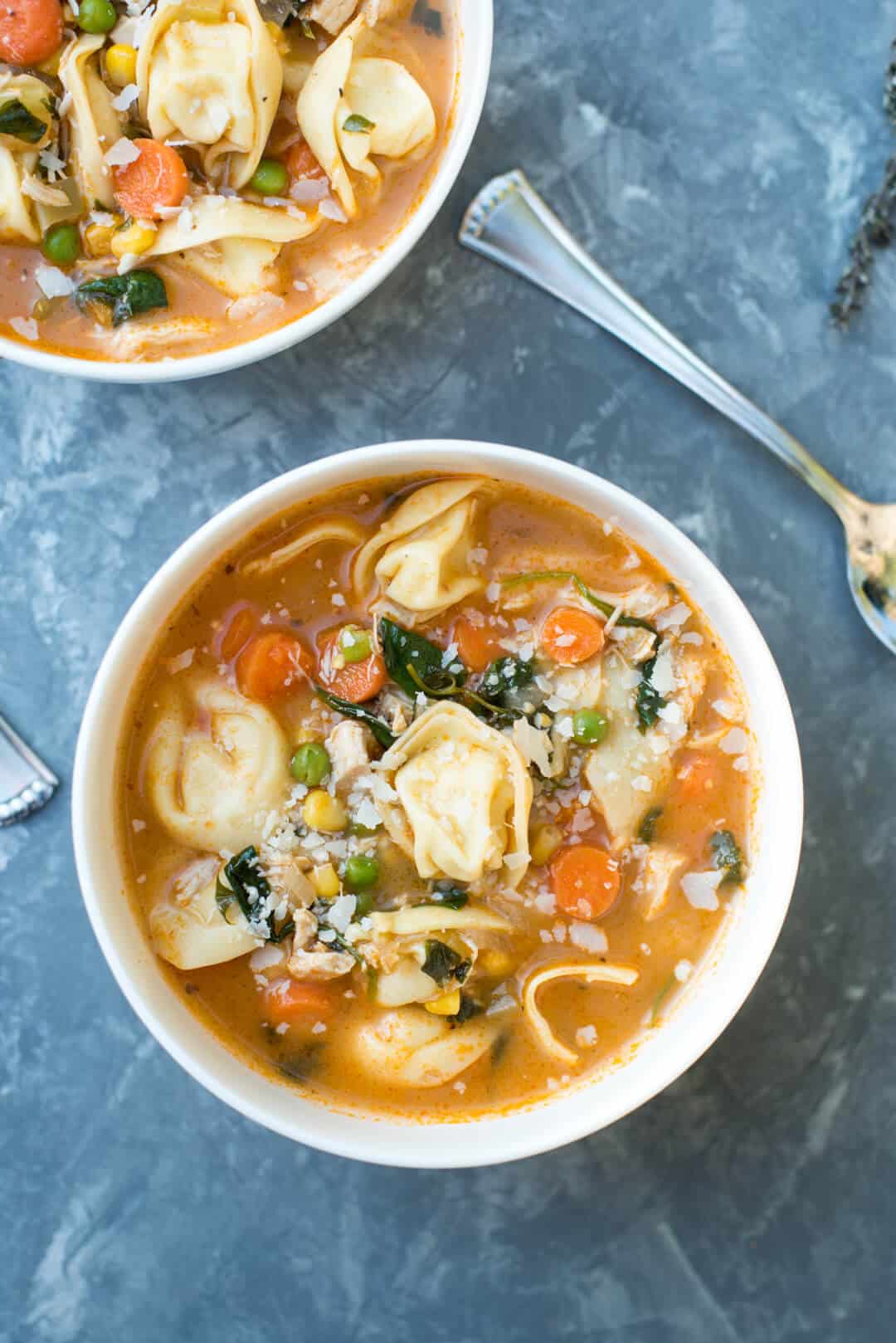 An over the top image of two white bowls of the Chicken Vegetable Tortellini Soup.