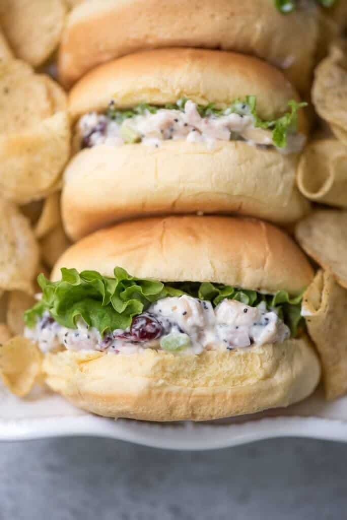 A close up of small buns filled with chicken salad and lettuce.