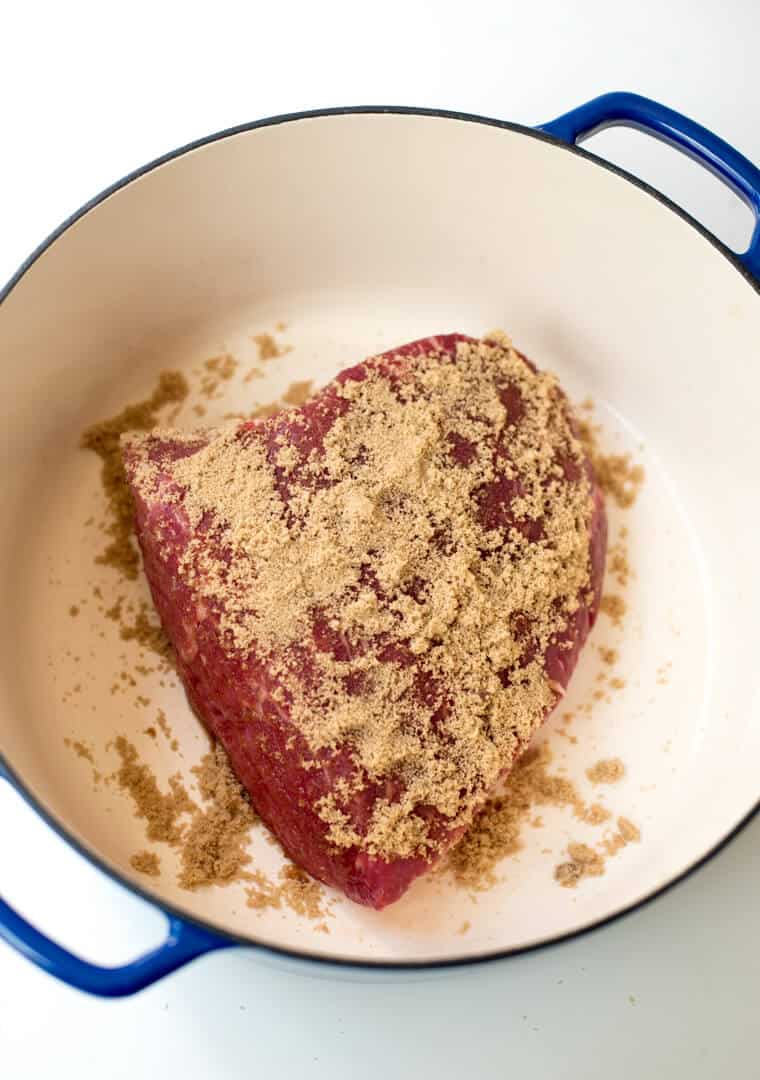  A corned beef brisket in a Dutch oven coated with brown sugar.