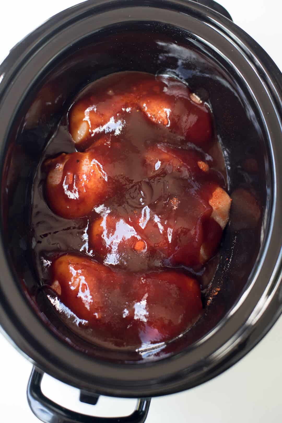 The chicken is covered with BBQ sauce and ready to cook.