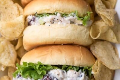 Cranberry Almond Poppy Seed Chicken Sandwiches on small buns surrounded by potato chips.