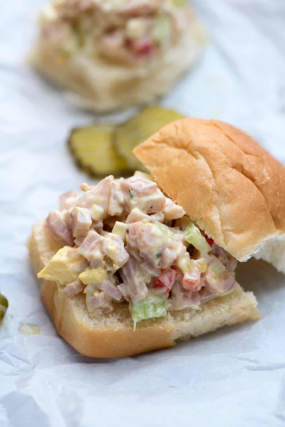 Ham Salad on a slider bun with pickles in the background.
