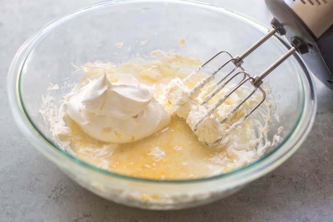 Beaters mix creamy pie ingredients in a mixing bowl.