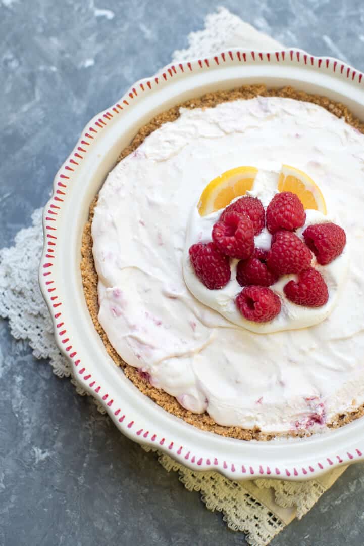 The finished pie decorated with raspberries and slices of lemon shot from over the top.