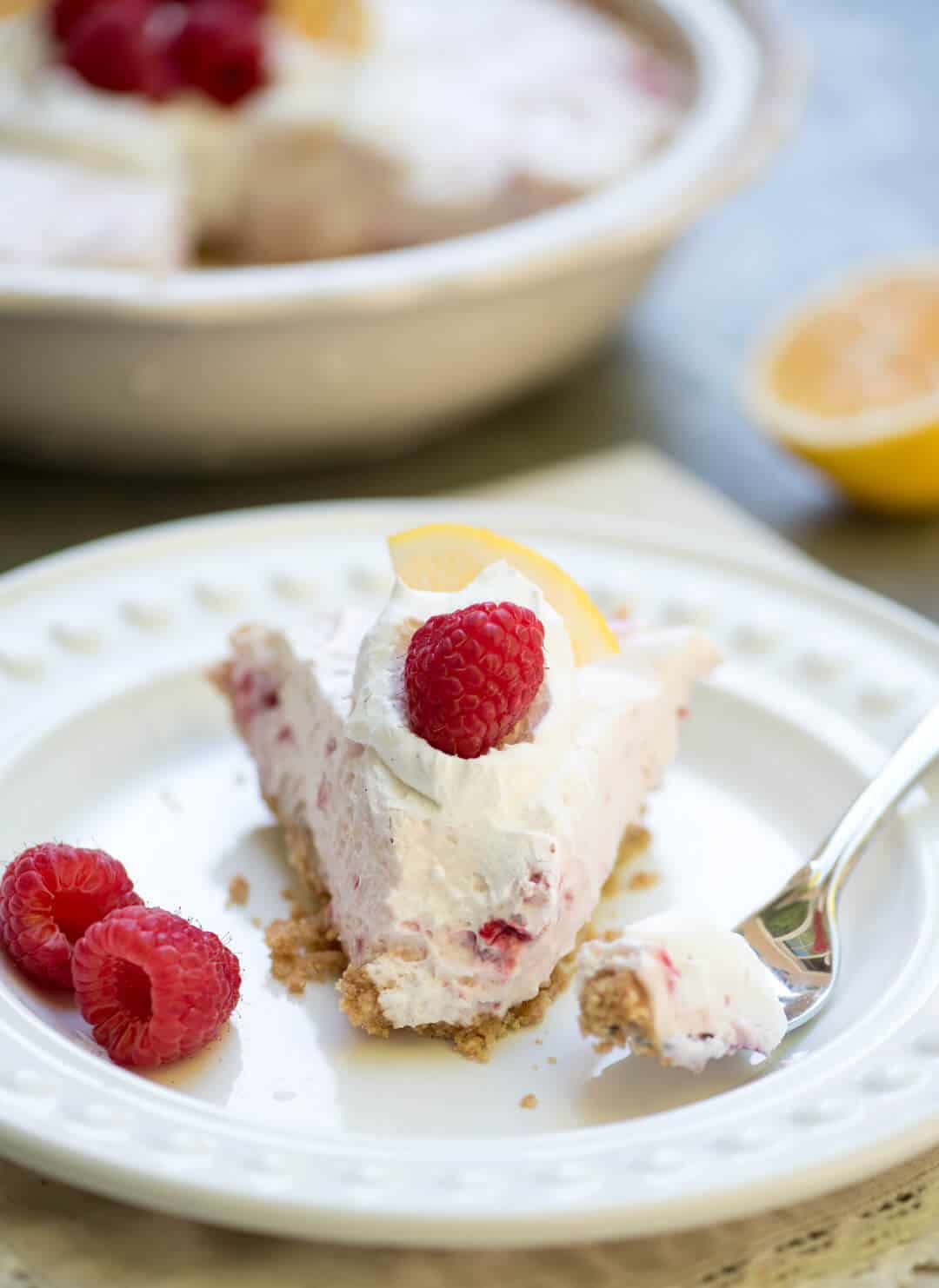 A fork lays on the white plate next to a slice of the pie.