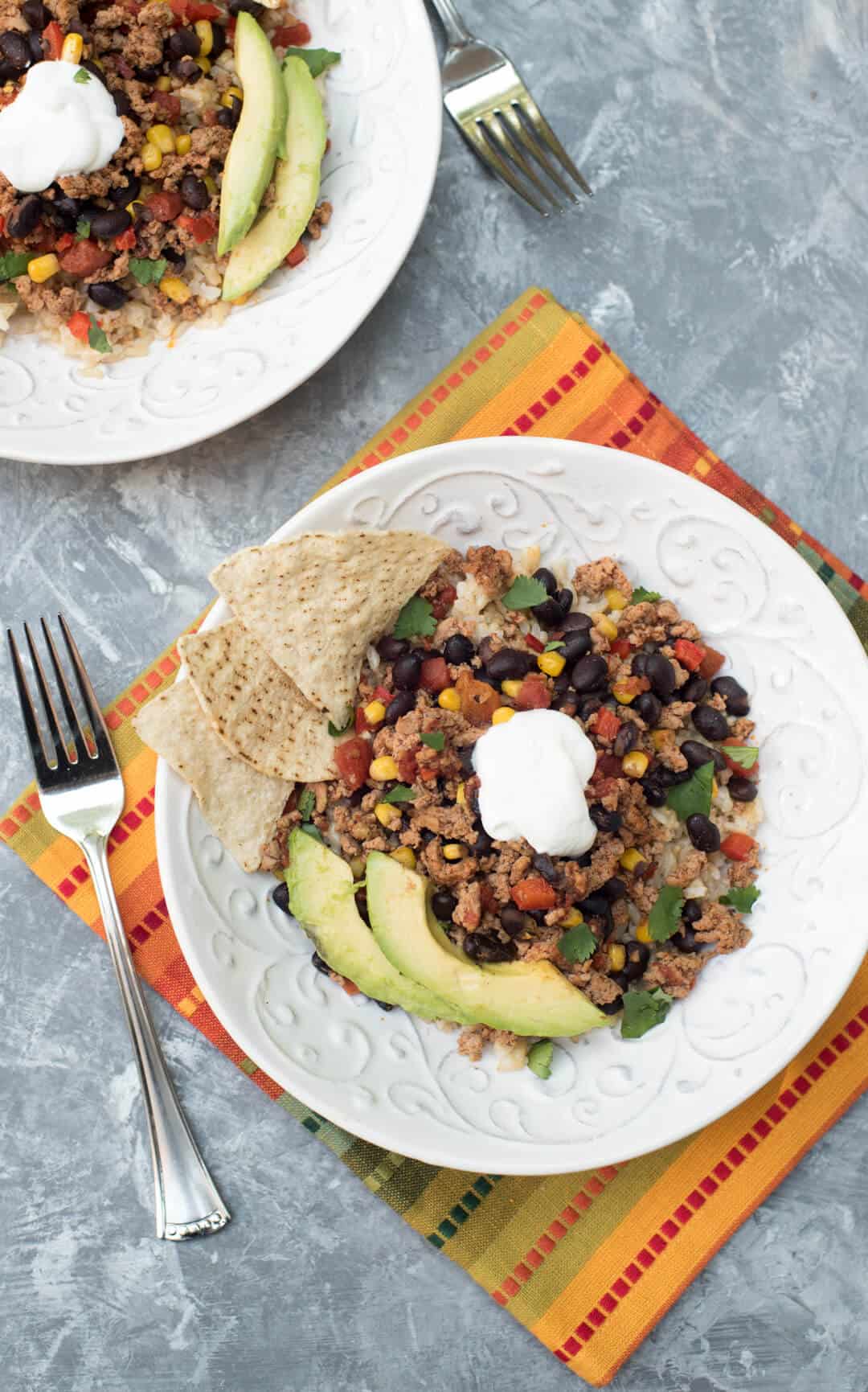  Southwest Turkey Taco mixture over brown rice in white bowls shot from over the top.