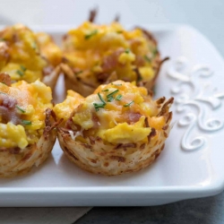 A close up of hash brown egg cups on a white platter.