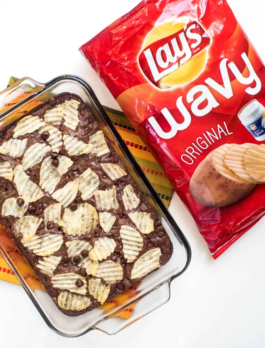 A bag of Wavy Lay's Potato Chips next to a dish of Potato Chip Brownies.