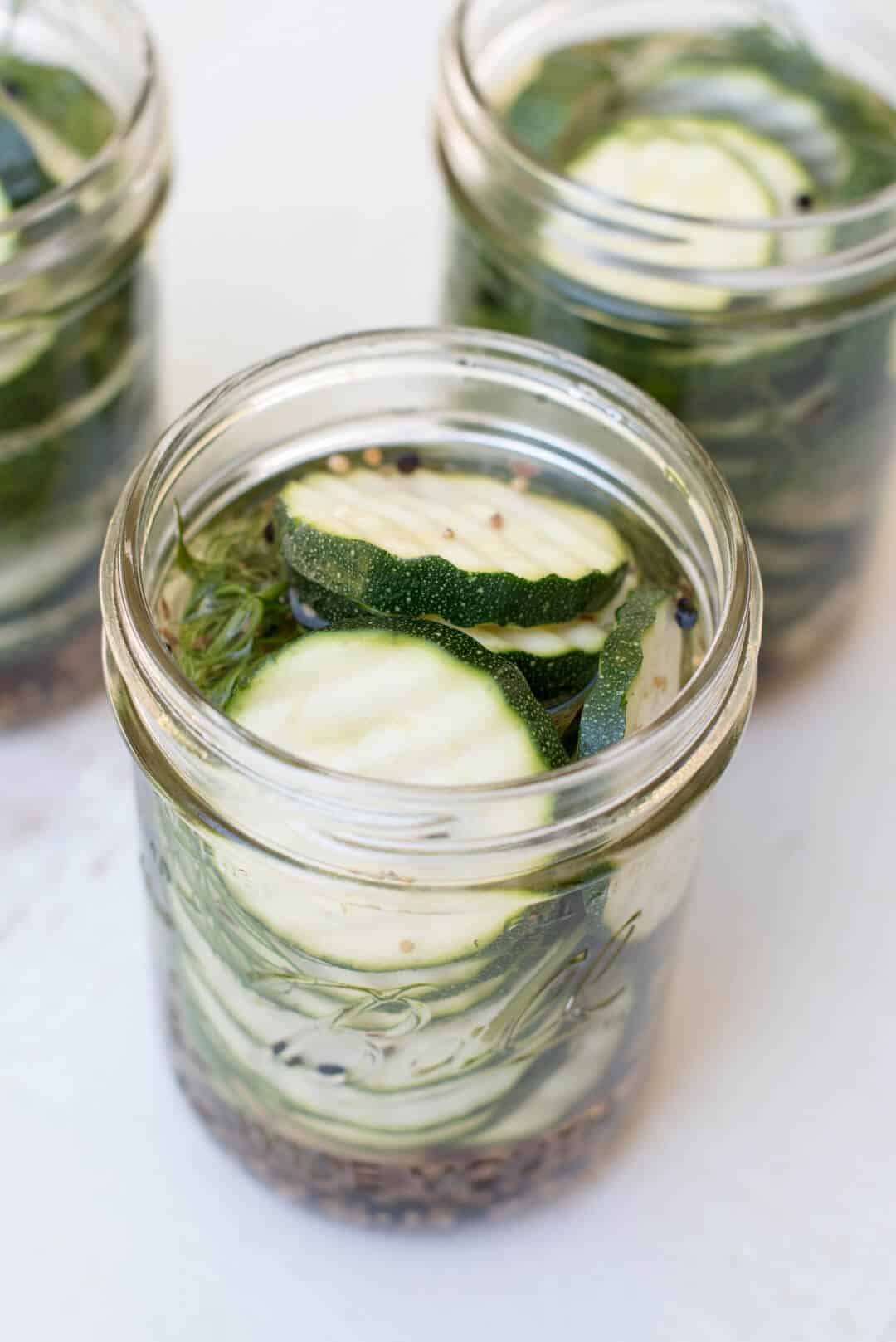 The brining liquid is poured into the mason jars.