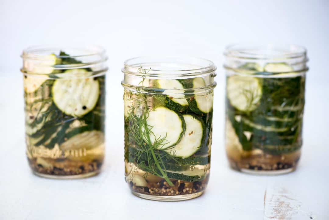 Three open mason jars full of Refrigerator Zucchini PIckles.