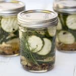 A mason jar filled with zucchini pickles and fresh dill.