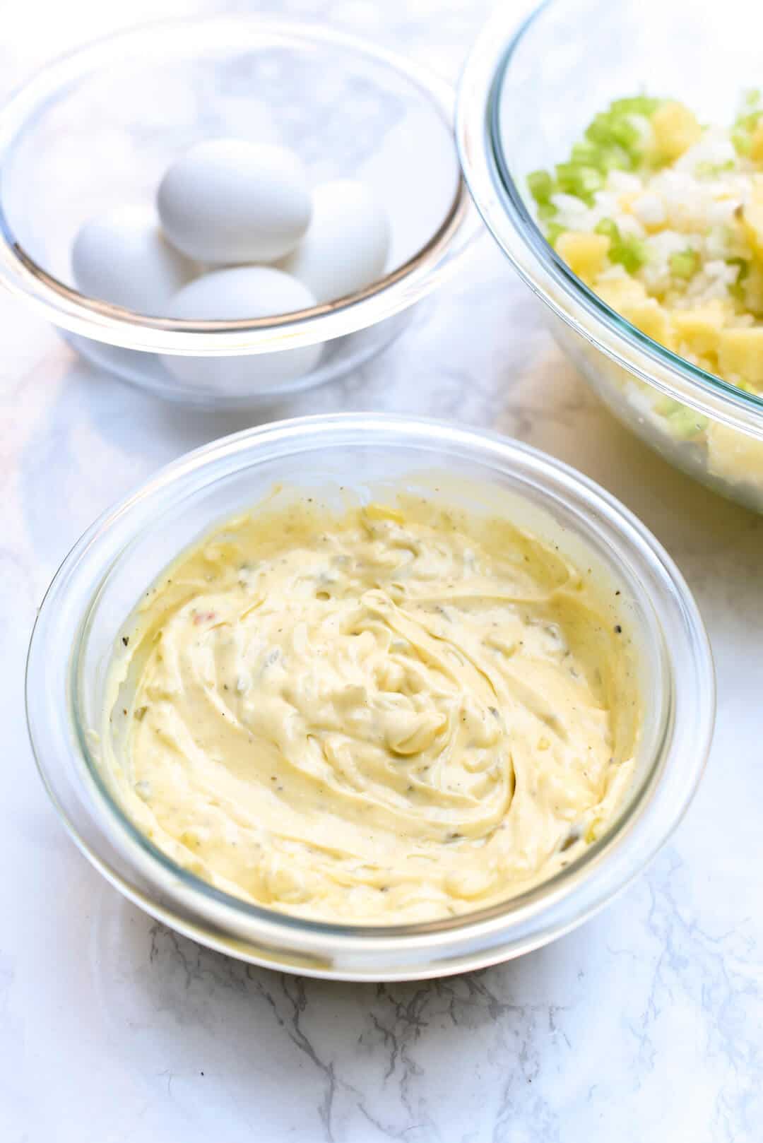 A close up image of the creamy dressing in a small glass bowl.