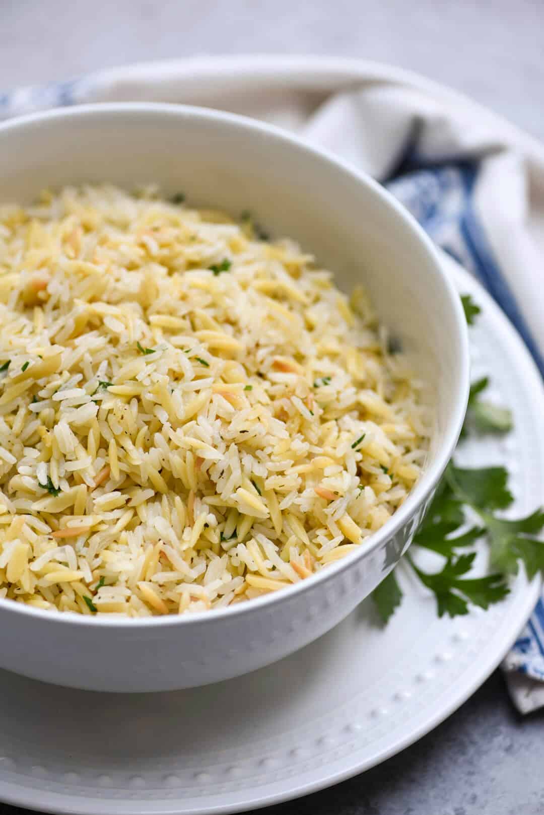 A white serving bowl filled with Almond Rice Pilaf.