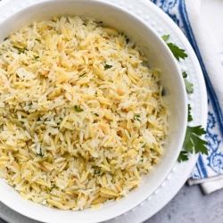 A bowl of Almond Rice Pilaf on a plate.