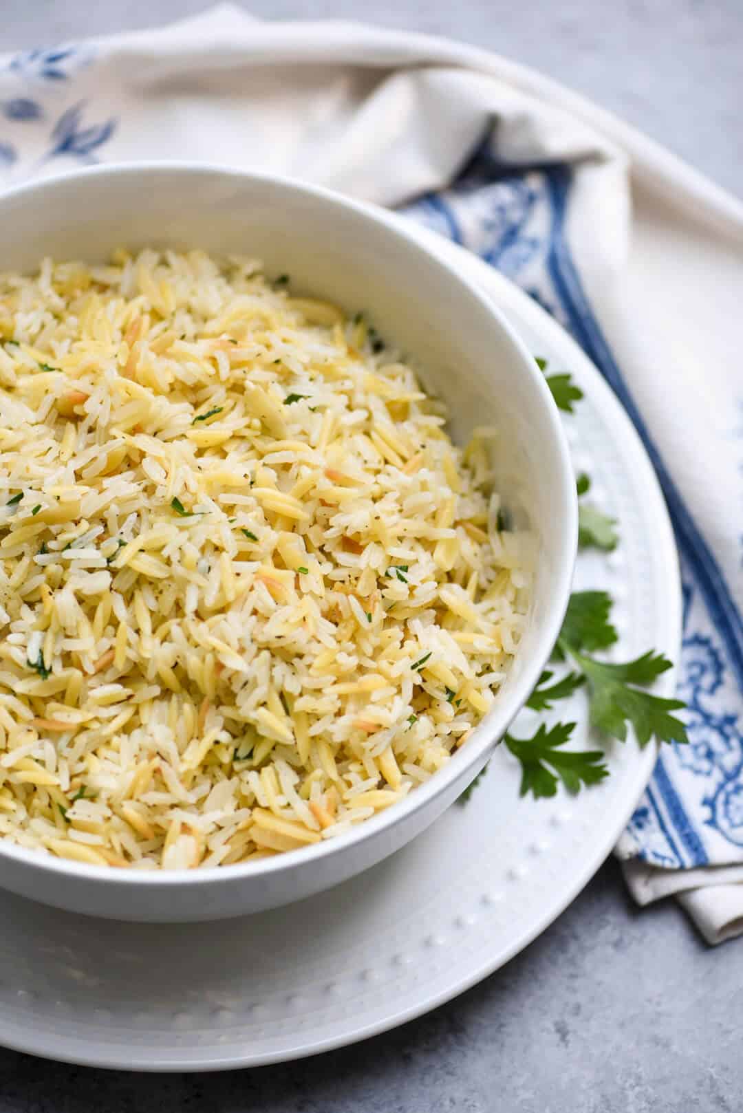 A white serving bowl filled with Almond Rice Pilaf.