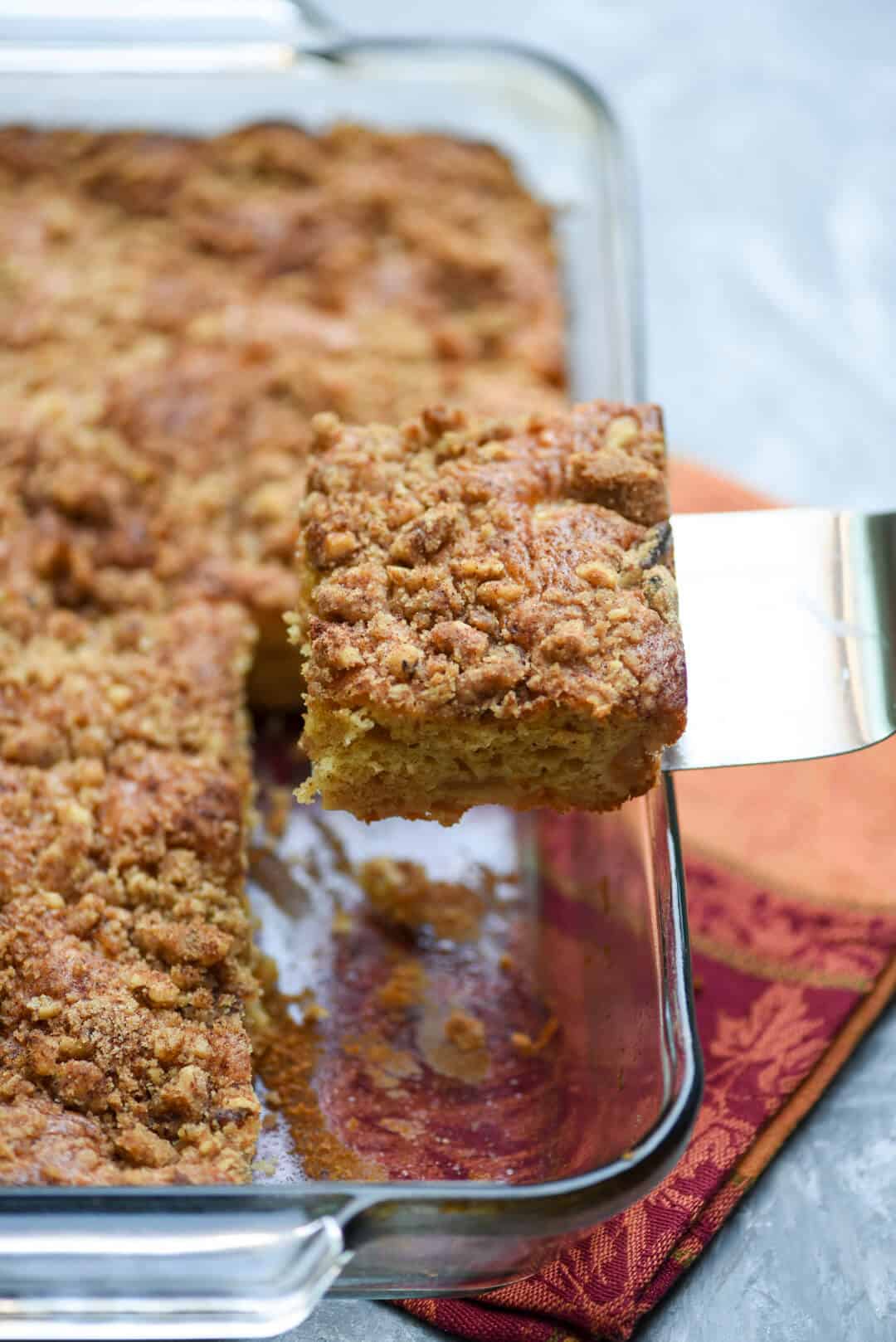 A spatula lifts a piece of cake from a baking dish.