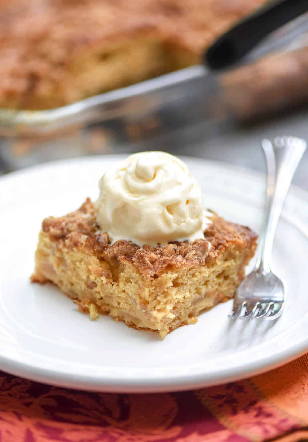 A piece of cake topped with whipped cream on a plate.