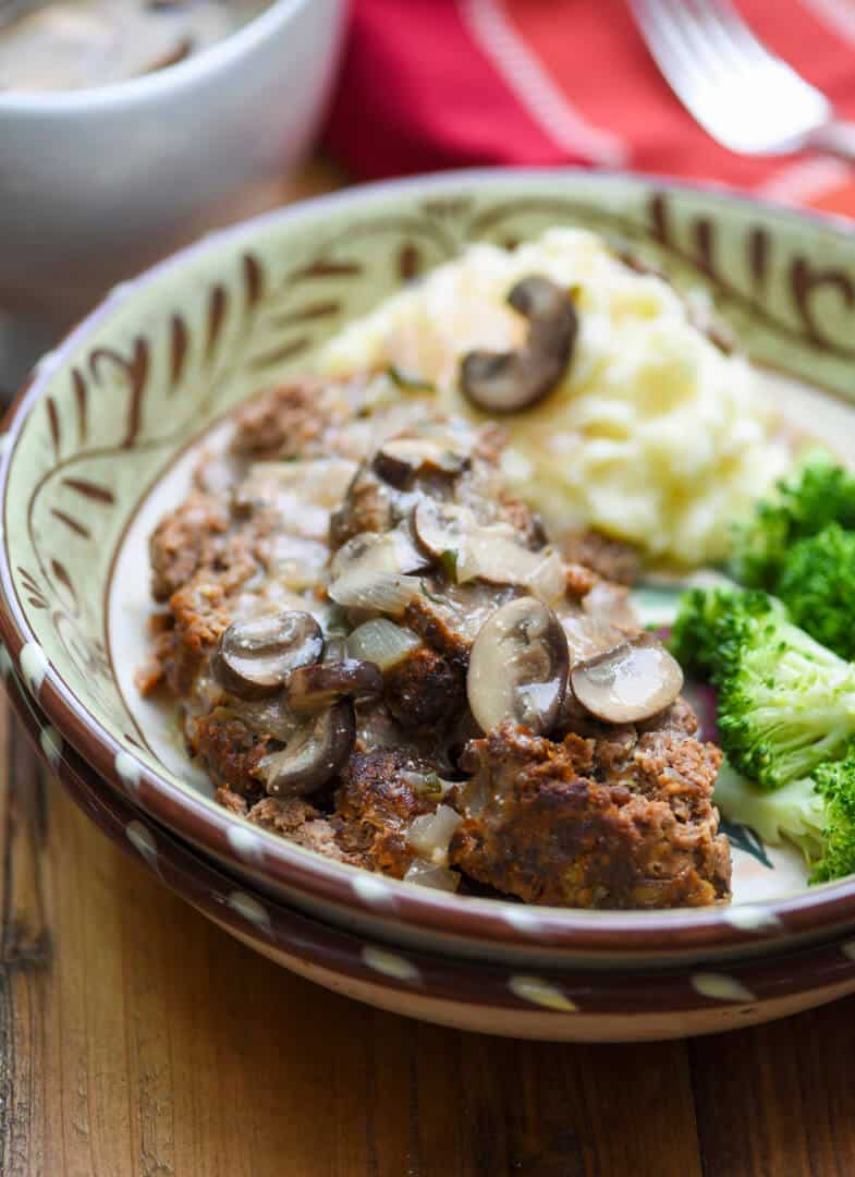 A bowl with meatloaf and sauce.