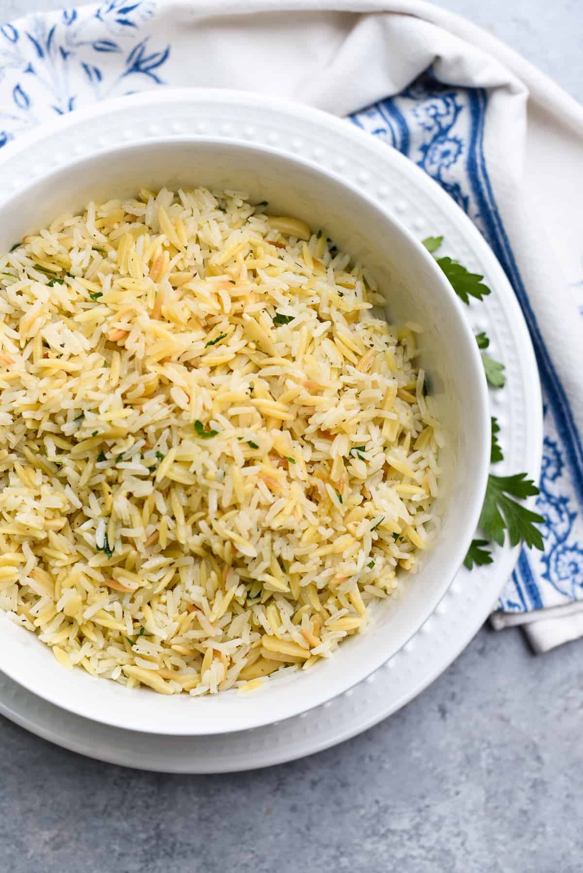 Almond Rice Pilaf in a white bowl on a plate.