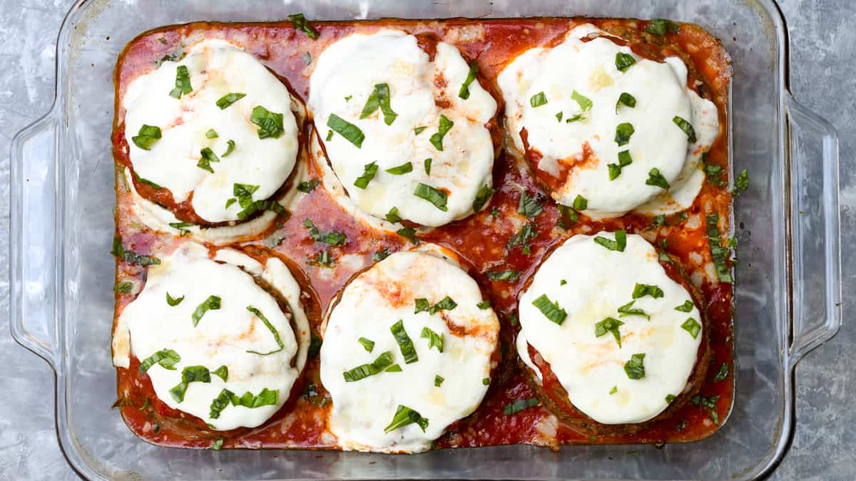 A top down shot of a baking dish filled with eggplant parmesan.