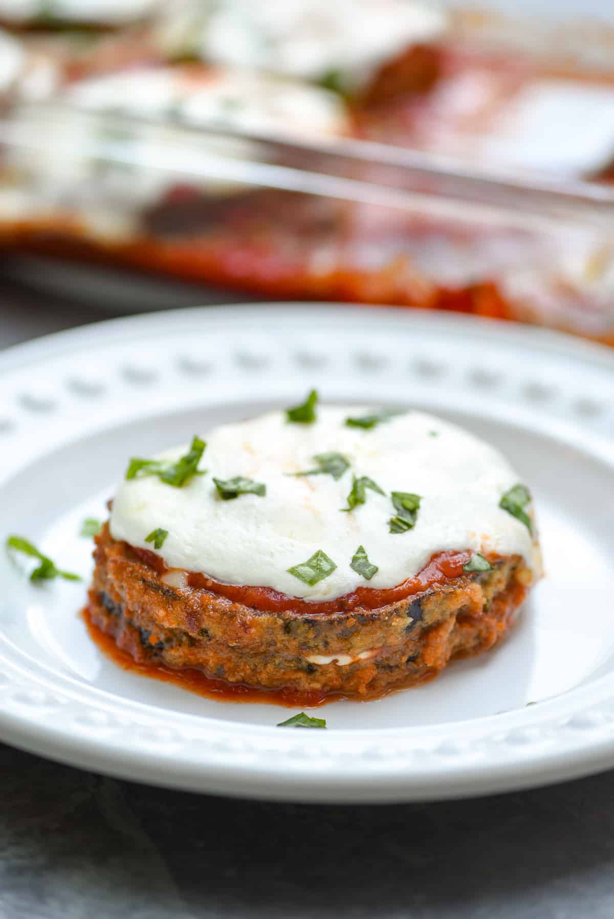 A serving of baked eggplant parmesan on a white plate.